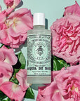 Lifestyle shot top view of Santa Maria Novella Rose Water (250 ml) with pink roses in the background