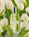 Lifestyle shot of Laboratory Perfumes Amber Eau de Toilette with pale colored tulips in the background and foreground