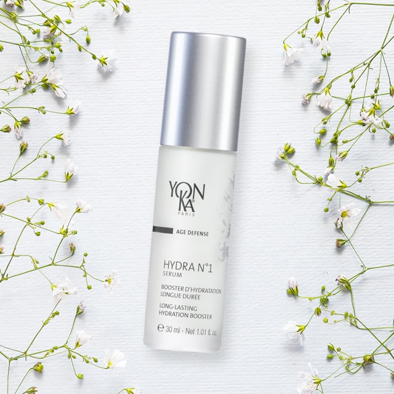 Yon-Ka Paris Hydra No. 1 Serum (30 ml) shown top view with small delicate white flowers in the background