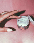 R+Co Badlands Dry Shampoo Paste - open jar and models hand