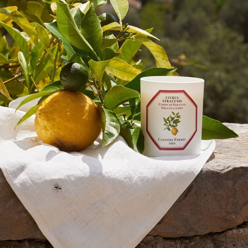 Lifestyle shot of Carriere Freres Siracusa Lemon Candle  (185 g) with lemon in the background