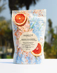 Lifestyle shot of Odacite Mood Cleansing Ayurvedic Bath Soak with palm trees in the background