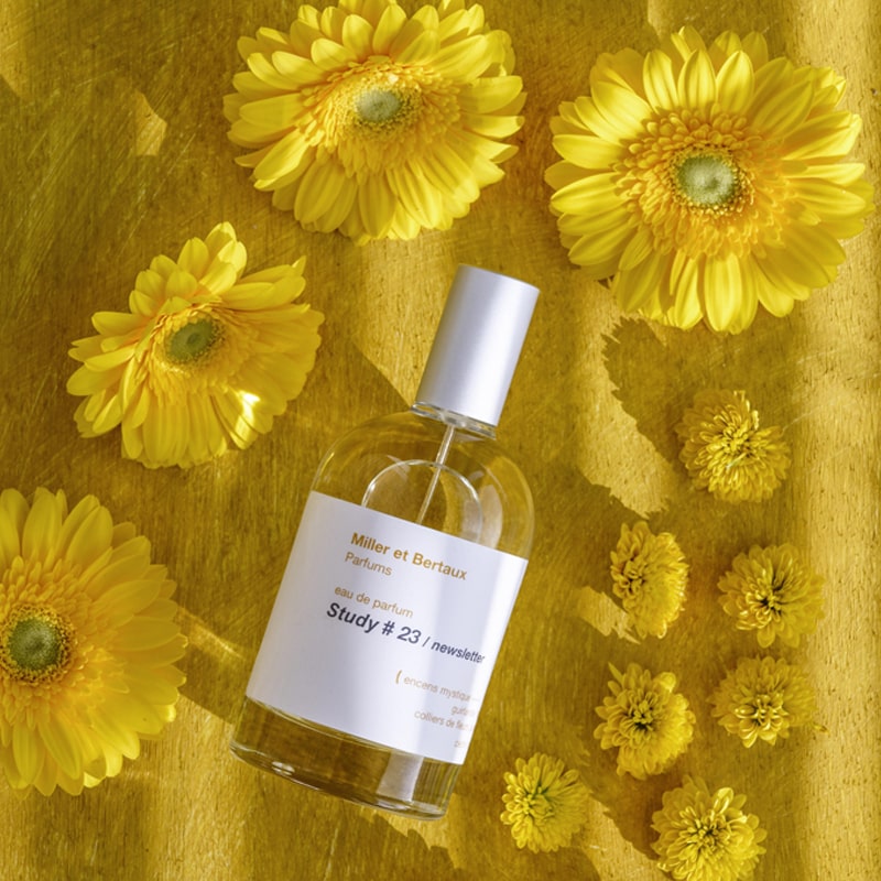 Miller et Bertaux Study #23 Eau de Parfum (100 ml) lifestyle shot top view, with yellow flowers in the background