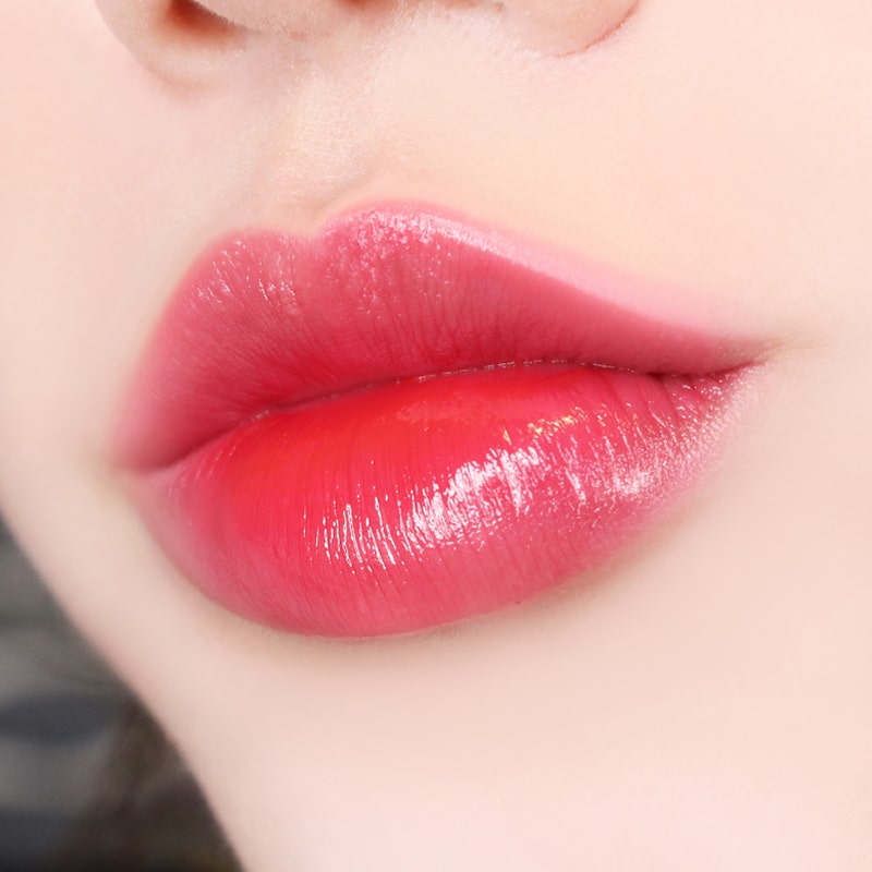 Paul + Joe Liquid Rouge Shine (0.28 oz, Plum Puree (02)) shown on model's lips