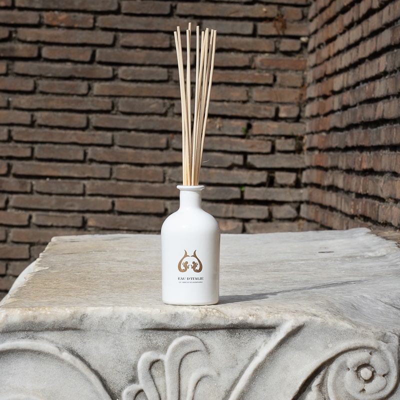 Lifestyle shot of Eau d’Italie Signature Scent Diffuser (240 ml) on top of ornate column with bricks in the background 