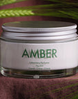 Lifestyle shot of Laboratory Perfumes Amber Cream shown on dark brown linen cloth