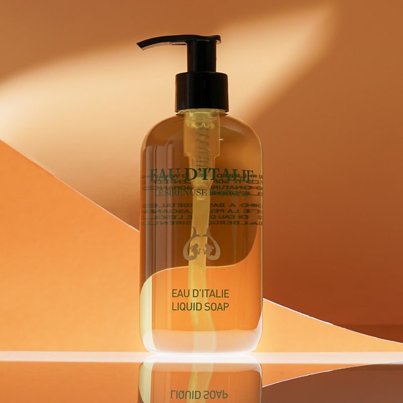 Lifestyle shot of Eau d&#39;Italie Signature Scent Liquid Soap (300 ml) with orange paper in the background