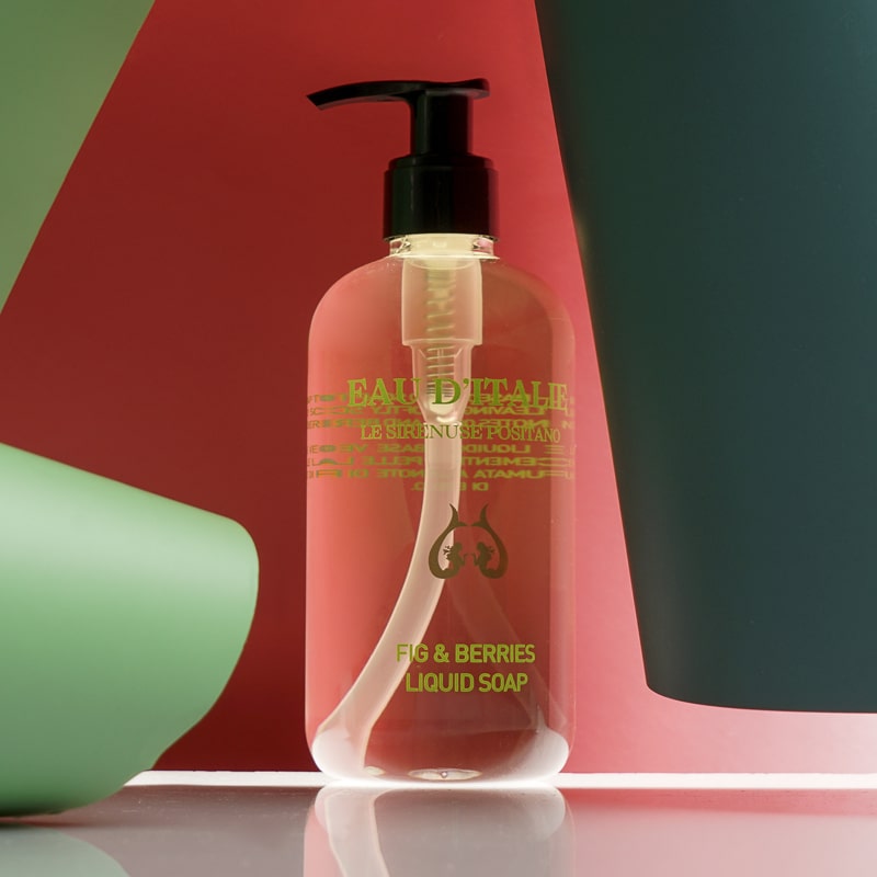 Lifestyle shot of Eau d&#39;Italie Fig &amp; Berries Liquid Soap (300 ml) with red and green paper in the background