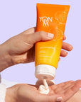 model squeezing Yon-Ka Paris Lait Hydratant Vitality – Mandarin into palm of hand