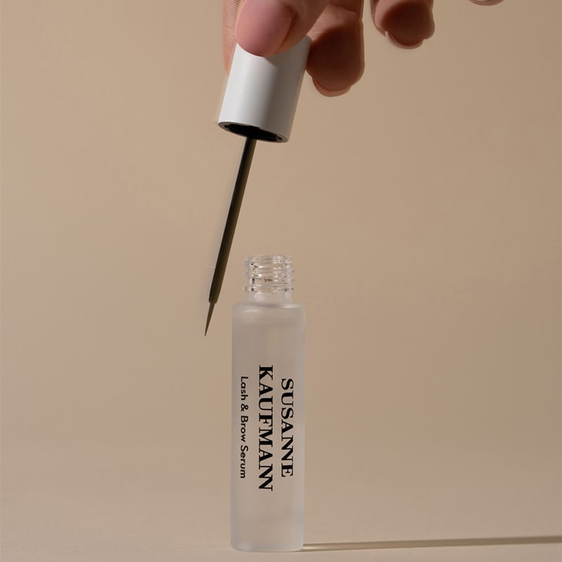 Susanne Kaufmann Lash & Brow Serum (5 ml)  - hand holding wand and open bottle