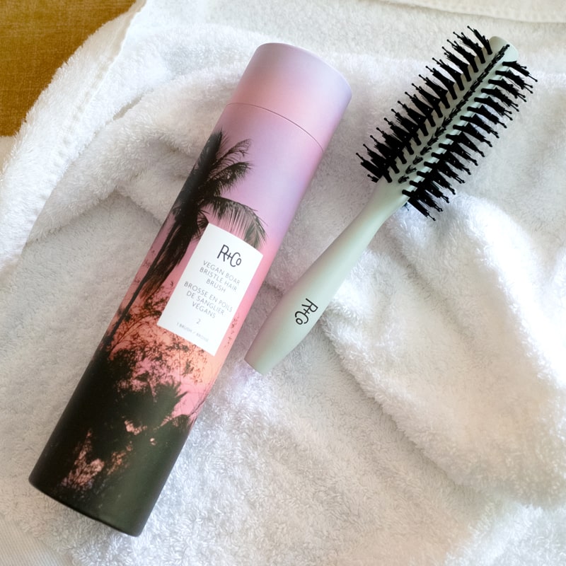 R+Co Vegan Boar Bristle Hair Brush #2 - Product and box shown on top of towel