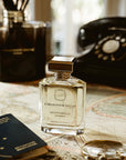 Ormonde Jayne Montabaco Intensivo Eau de Parfum - lifestyle shot of perfume bottle, glasses, phone on a map