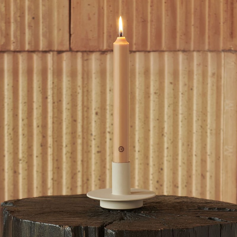 Carriere Freres Cedar 8" Taper Candles - lit candle in candle holder on wood table