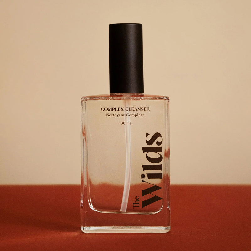 The Wilds Complex Cleanser - Product shown on red backhground