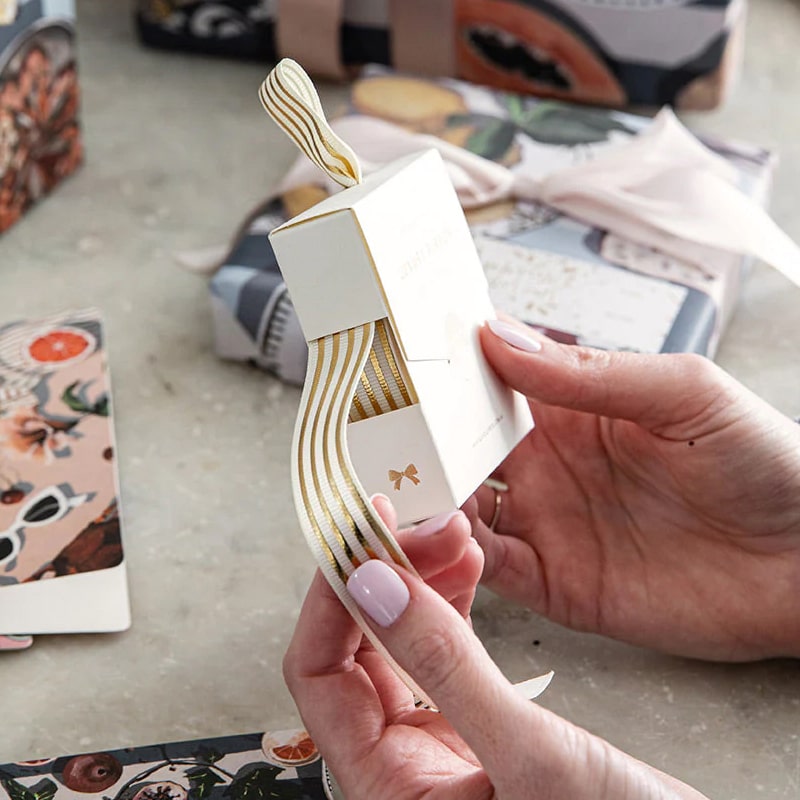 Bespoke Letterpress Cream Gold Foil Striped Ribbon - Model shown holding ribbon box wrapping gifts
