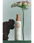 Roz Air Thickening Spray - Product shown with flowers