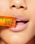 Nuxe Reve de Miel® Honey Lip Care - Closeup of model holding product against lips