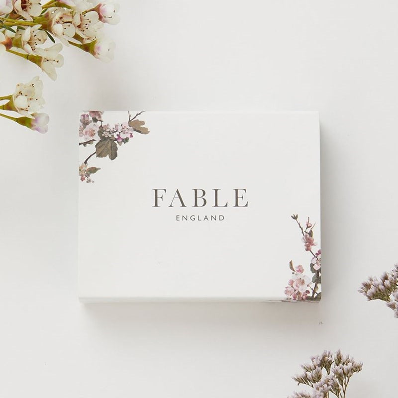 Fable England Rabbit Brooch - Product packaging shown by flowers