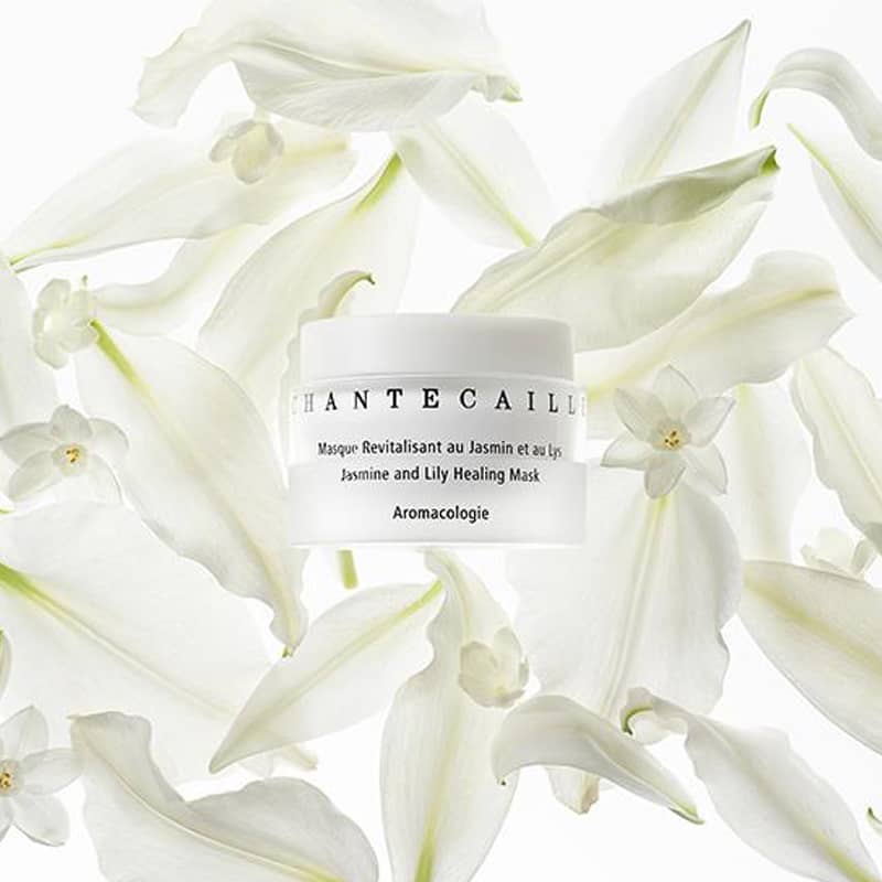 Beauty shot top view of Chantecaille Jasmine &amp; Lily Healing Mask 50 ml with jasmine and lily in the background