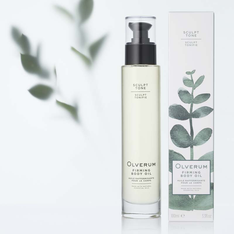 Olverum Firming Body Oil (100 ml) with box and leaves in the background
