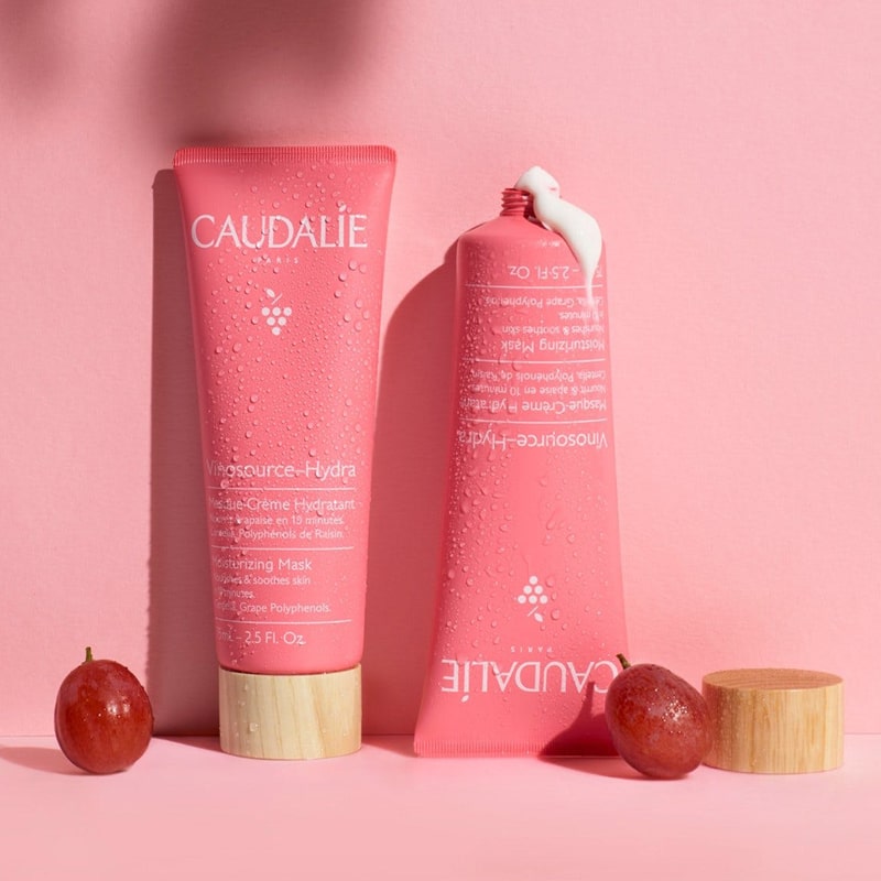 Caudalie Vinosource-Hydra Moisturizing Mask beauty shot with one tube on cap and one tube with product coming out and grapes as accents