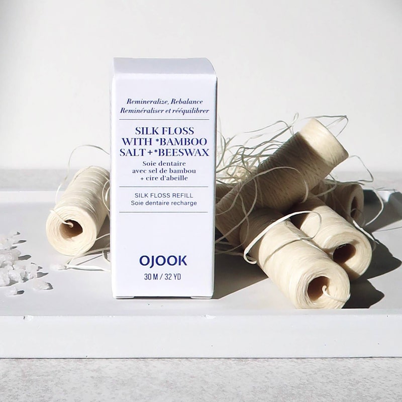 OJOOK Silk Floss Refill lifestyle shot showing several rolls of floss beside box (sold individually)