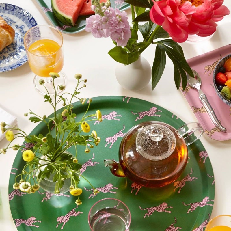 Blu Kat Pink Leopard Round Serving Tray - lifestyle shot of tray with flowers and a teapot on it with other food in the background
