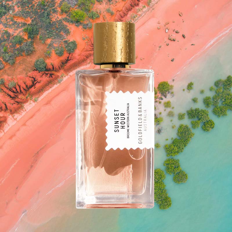 Mood shot of Goldfield &amp; Banks Sunset Hour Perfume 100 ml with aerial view of ocean and pink sand in the background