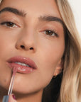 Model applying Close up of Roen Beauty Kiss My Lip Balm – Charlie (3 ml) on lips
