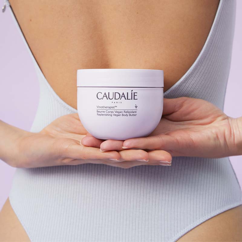 Caudalie Vinotherapist Replenishing Vegan Body Butter showing model holding product in hands behind back
