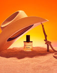 D.S. & Durga Sweet Do Nothing Eau de Parfum showing bottle underneath cowboy hat on sand