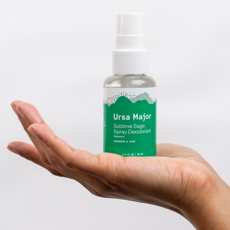 Ursa Major Sublime Sage Spray Deodorant 1.7 oz in palm of model's hand