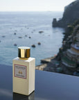 Eau d'Italie Mystic Sunset Eau de Parfum Spray (100 ml) with the Positano cliffside and bay in the background