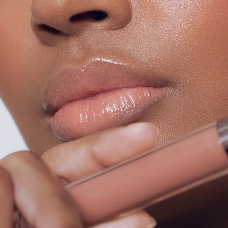 Close up of Roen Beauty Kiss My Liquid Lip Balm - Lola on lips of model with dark skin tone