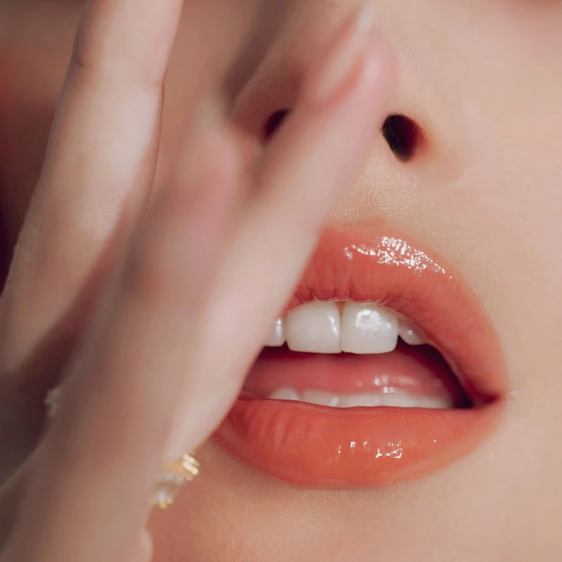 Close up of Roen Beauty Kiss My Liquid Lip Balm – Dodi on lips of model with light skin tone