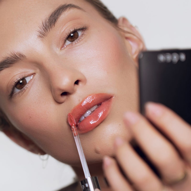 Model applying Roen Beauty Kiss My Liquid Lip Balm – Dodi on lips