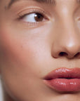 Close up of model with fair skin tone wearing Roen Beauty Kiss My Liquid Lip Balm – Jude
