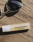 Susanne Kaufmann Eye Rescue Serum beauty shot of tube beside sunglasses (not included)