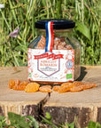Les Abeilles de Malescot Apricot & Rosemary Honey Candies beauty shot of candy jar on a tree stump with candies in front of the jar