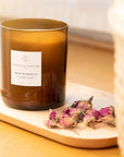 Essential Parfums Rose Magnetic Scented Candle - Product displayed on tray next to flowers