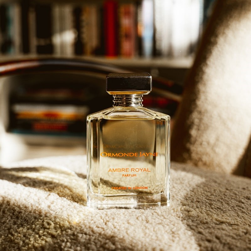 Ormonde Jayne Ambre Royal Eau de Parfum - bottle on chair with bookshelf in background