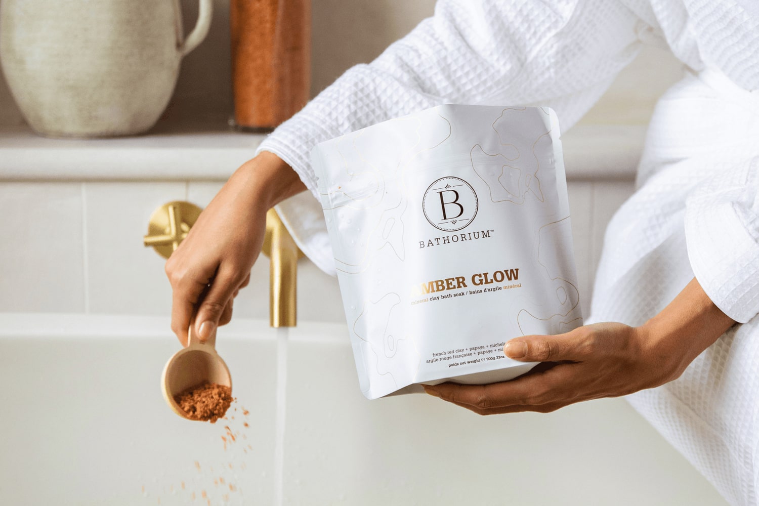 Model adding Bathorium Amber Glow Clay Mineral Soak to bath water