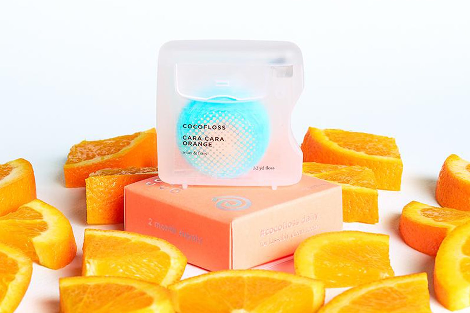 Beauty shot of Cocofloss Cara Cara Orange Floss 32 yards with orange slices