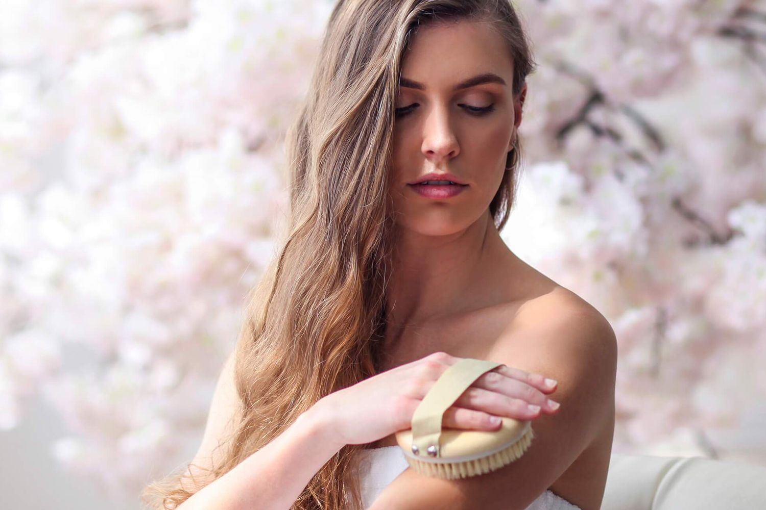 Young Woman using Daily Concepts Daily Detox Messaging Brush on her upper arm