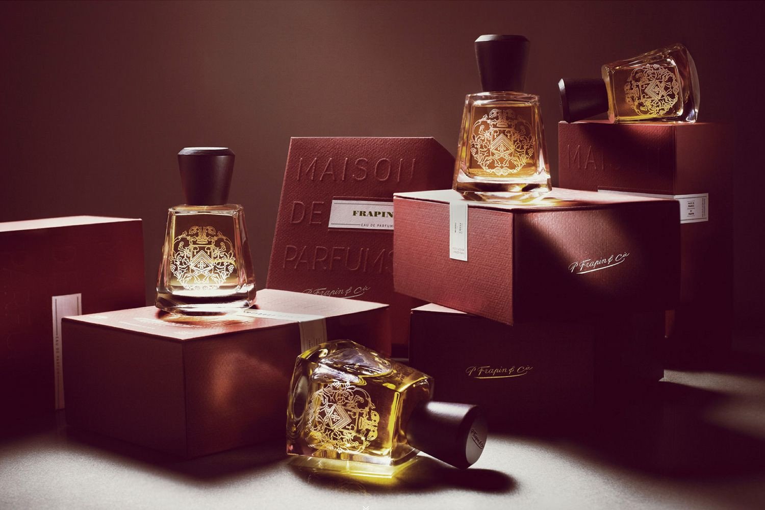 A moody shot of a selection of Frapin fragrance bottles and boxes