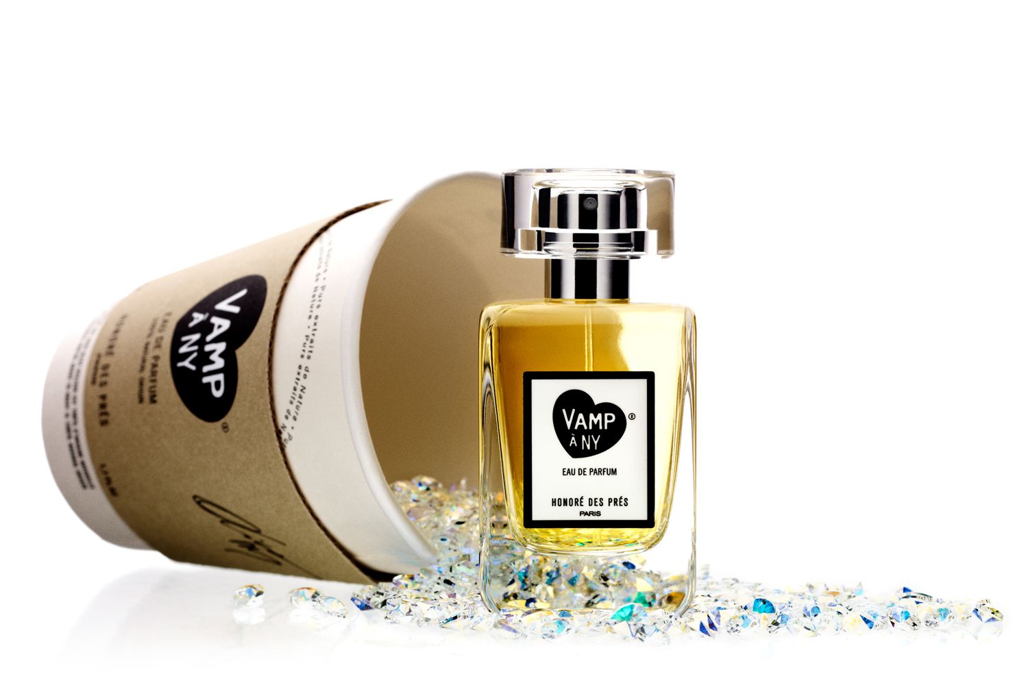 Beauty shot of Honore des Pres Vamp a N.Y. Eau de Parfum with coffee cup laying down in background with gemstones spilling out