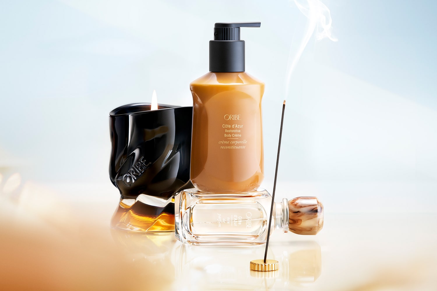 Lifestyle shot Oribe Cote d'Azur products including Scented Candle, Restorative Body Creme, Eau de Parfum and Incense