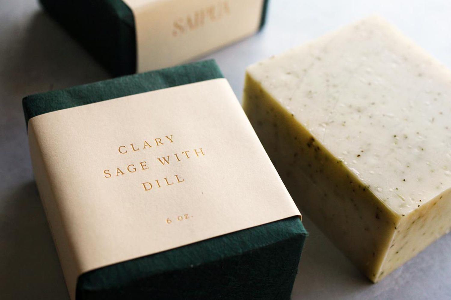 Saipua Clary Sage with Dill bar soap shown with outer wrapping and without.