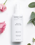 Lifestyle shot of Leonor Greyl Algues et Fleurs Conditioner Curl Enhancer Styling Spray (150 ml) with pink roses and leaves in the background