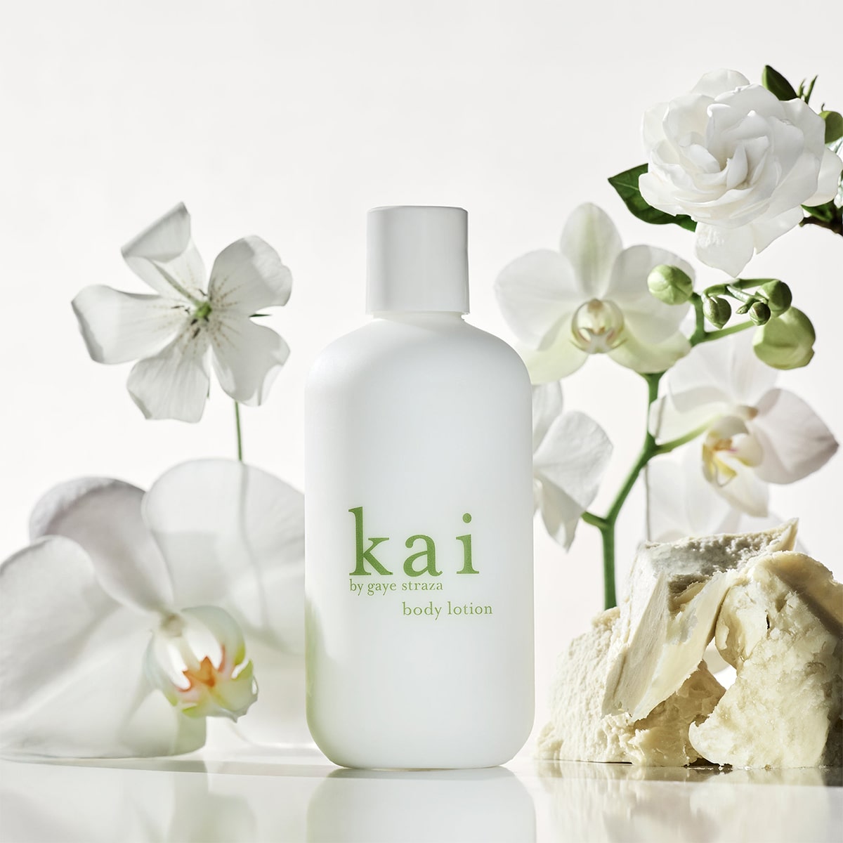 Kai Fragrance Body Lotion (8 oz) with white flowers in the background